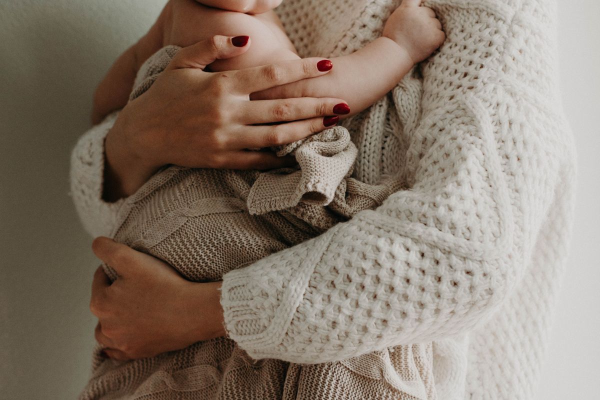 A parent gently holding and soothing their baby at home