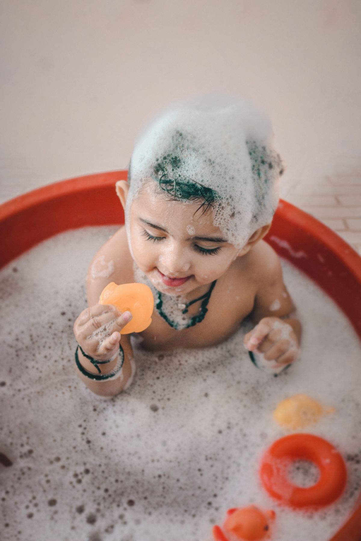 A joyful toddler playing during bath time